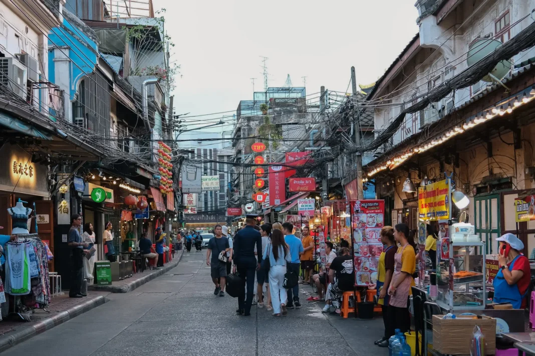 Bangkok Chinatown'da akşam saatlerinde kalabalık bir sokak ve sokak satıcıları