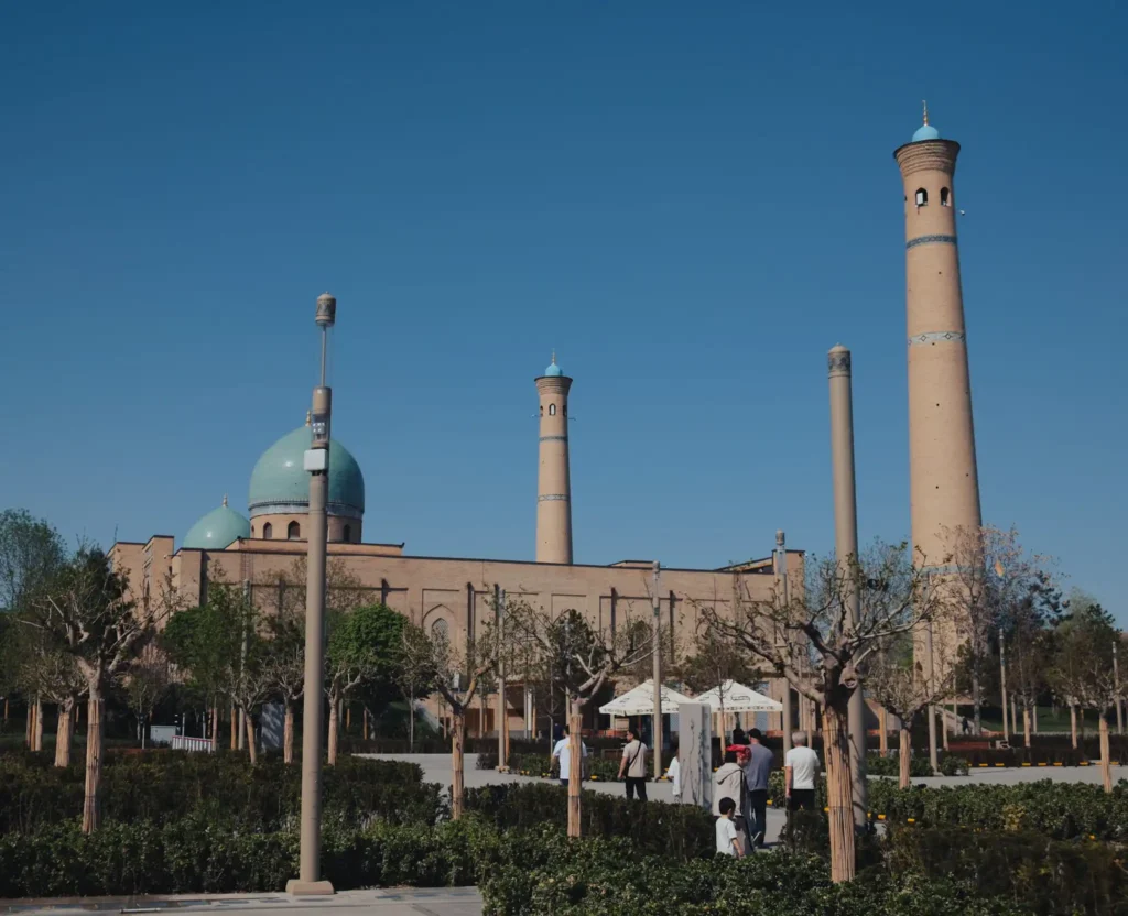 Güneşli ve açık bir gökyüzü altında Taşkent'teki tarihi Hazreti İmam Camii Kompleksi'nin turkuaz kubbeleri ve uzun minareleri.